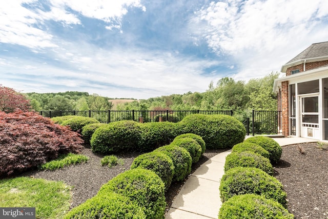 view of yard featuring fence and a sunroom