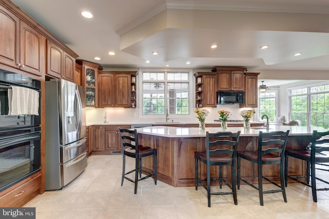 kitchen with black appliances, open shelves, recessed lighting, crown molding, and a kitchen bar