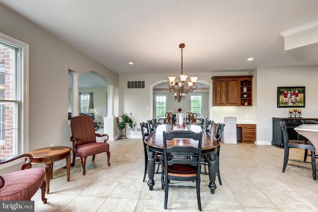 dining area with a chandelier, arched walkways, ornate columns, light tile patterned flooring, and recessed lighting