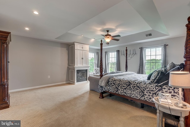 bedroom with a tray ceiling, baseboards, light colored carpet, and recessed lighting