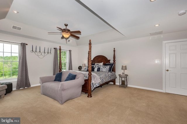 bedroom featuring light colored carpet, baseboards, a tray ceiling, recessed lighting, and a ceiling fan