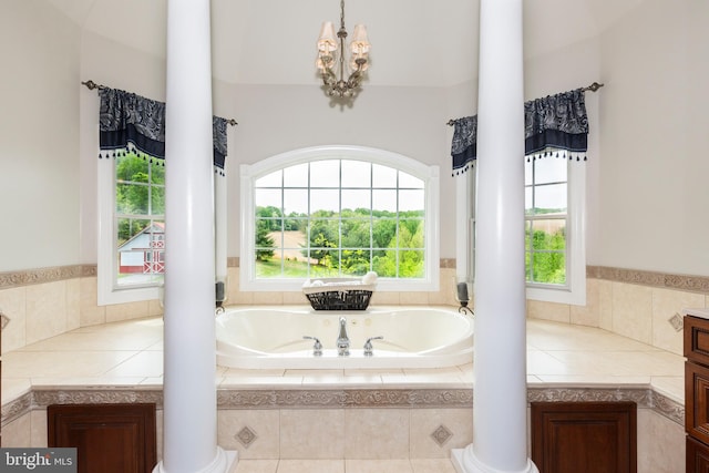 full bathroom with decorative columns, a garden tub, and a chandelier