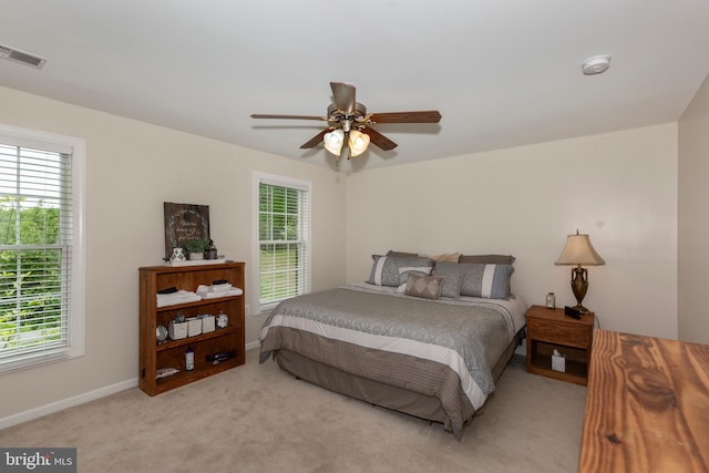bedroom with light carpet, baseboards, and a ceiling fan