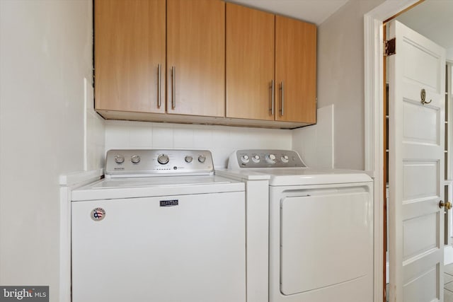 washroom featuring cabinet space and washing machine and clothes dryer
