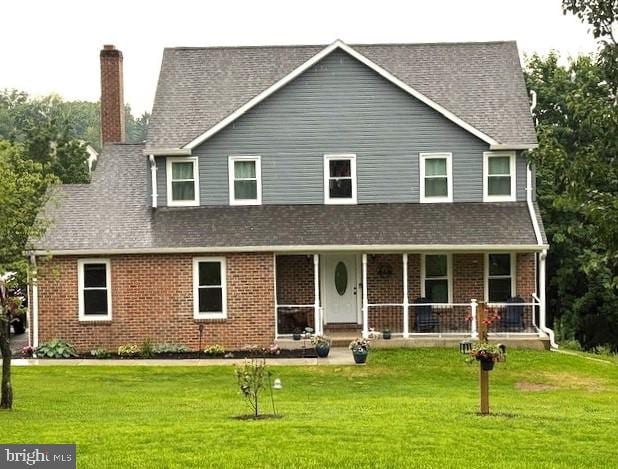 5010 Waxton Ct, Monrovia, MD 21770 - view of front of property featuring a chimney, covered porch, a front yard, and brick siding