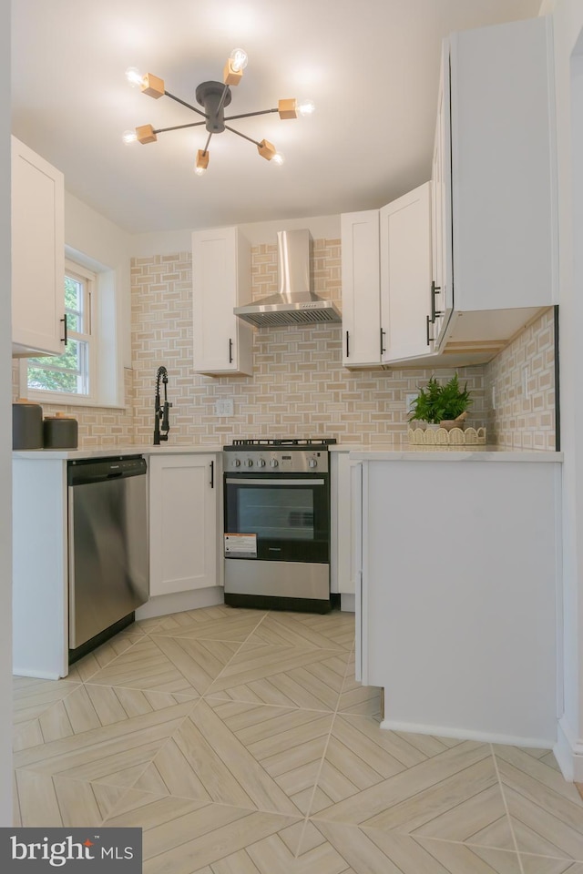 5446 Varnum St, Bladensburg, MD 20710 - kitchen featuring appliances with stainless steel finishes, wall chimney exhaust hood, white cabinetry, and light countertops
