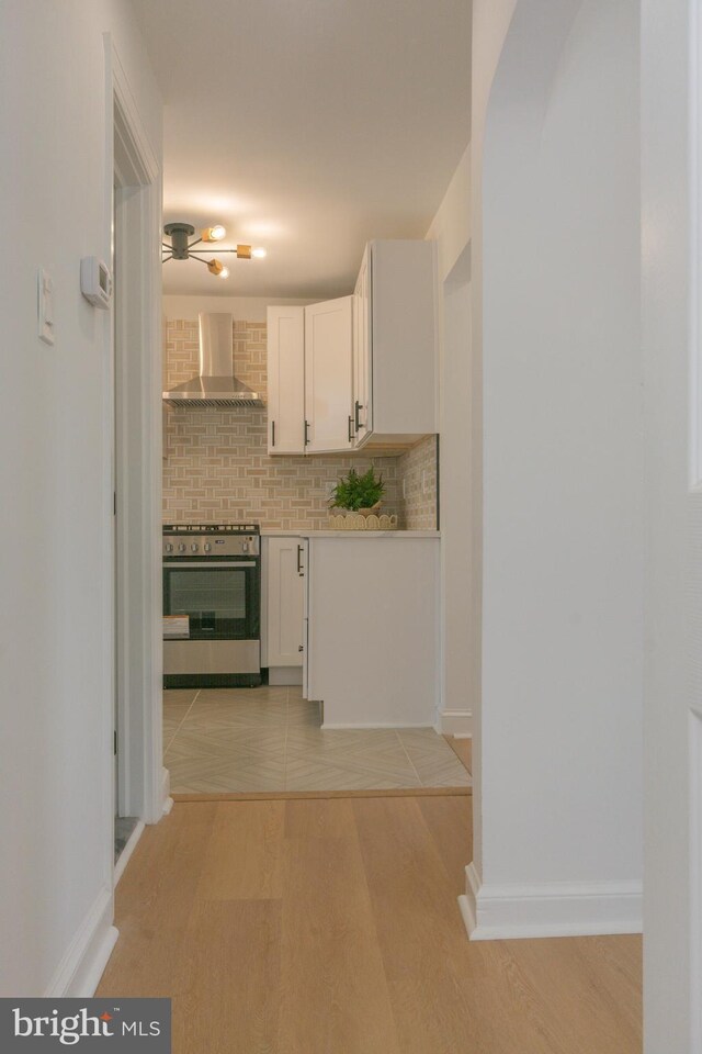 5446 Varnum St, Bladensburg, MD 20710 - kitchen featuring wall chimney exhaust hood, white cabinets, ceiling fan, wall oven, and light wood finished floors