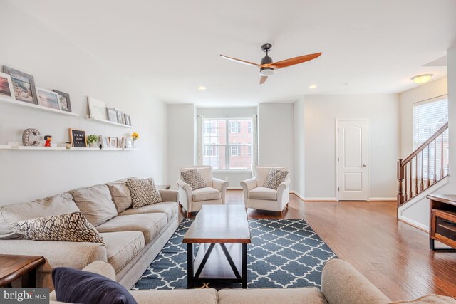 living room with wood finished floors, healthy amount of natural light, a ceiling fan, stairway, and recessed lighting