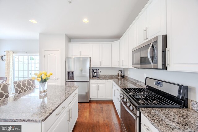kitchen featuring appliances with stainless steel finishes, white cabinets, recessed lighting, dark wood-style floors, and light stone countertops