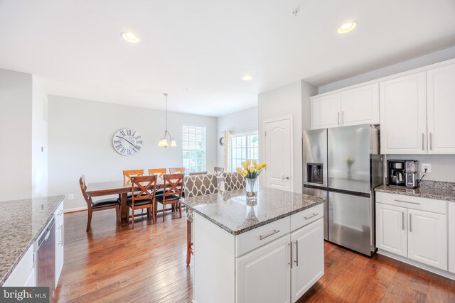 kitchen featuring appliances with stainless steel finishes, white cabinets, wood finished floors, light stone countertops, and recessed lighting