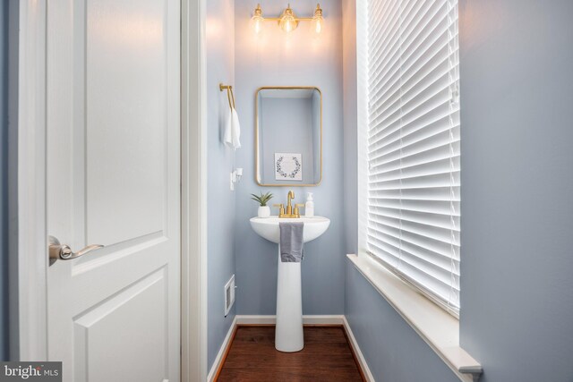 bathroom with wood finished floors, baseboards, and a sink