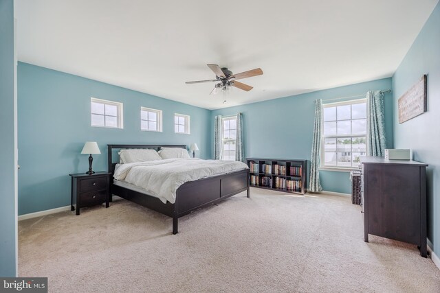 carpeted bedroom featuring baseboards and ceiling fan