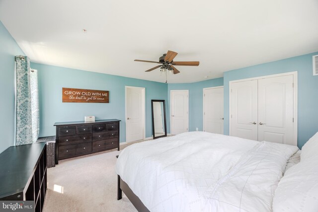 carpeted bedroom with two closets and ceiling fan