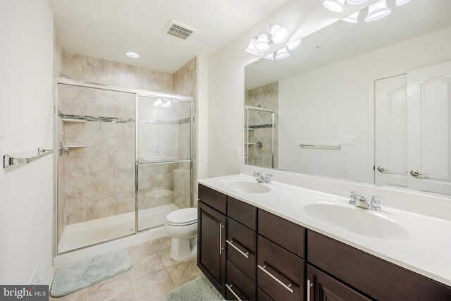 bathroom featuring a shower stall, toilet, tile patterned flooring, and double vanity