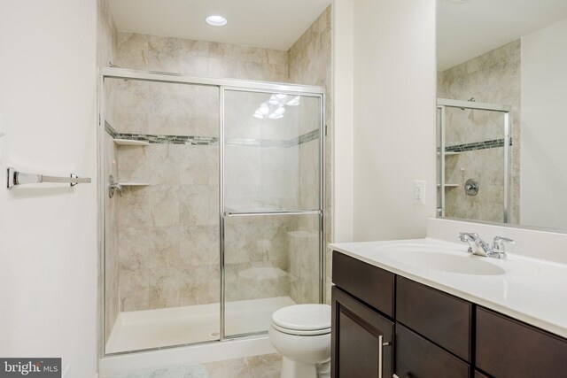 full bathroom with a shower stall, toilet, and vanity