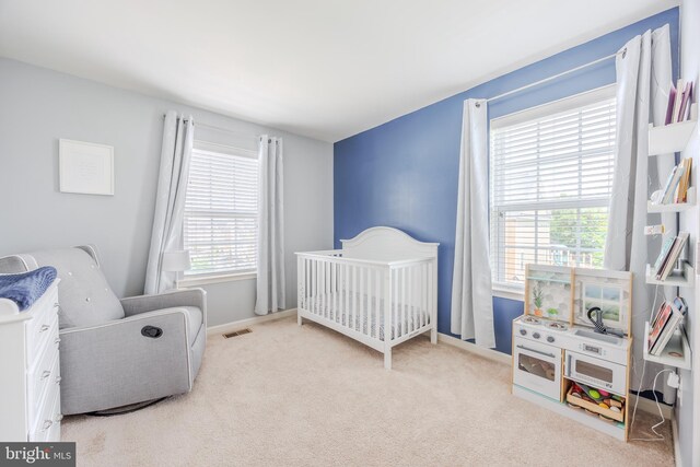 bedroom featuring carpet flooring, a nursery area, and baseboards