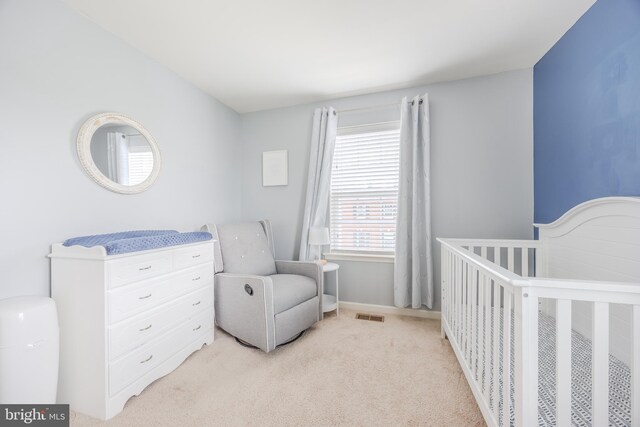 bedroom with light colored carpet and a crib