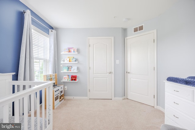 bedroom featuring carpet floors, baseboards, and a crib