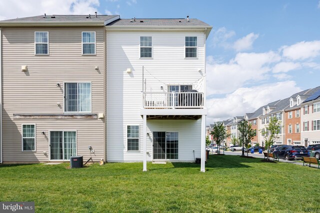back of property featuring a lawn, cooling unit, and a residential view
