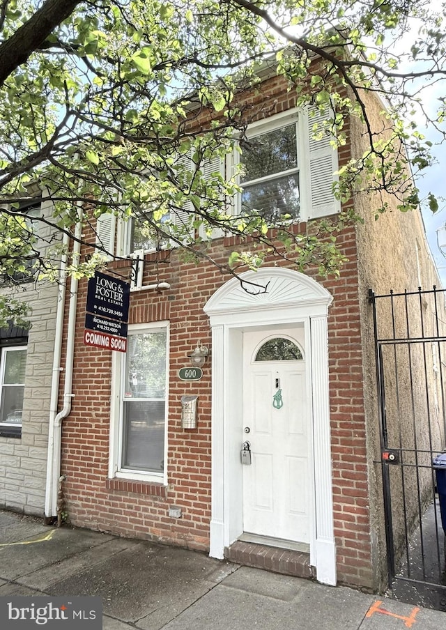 doorway to property with brick siding