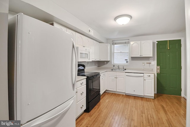 kitchen featuring white appliances, a sink, light countertops, white cabinetry, and light wood-style floors