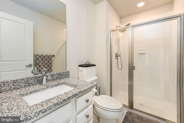 bathroom featuring a stall shower, toilet, vanity, and recessed lighting