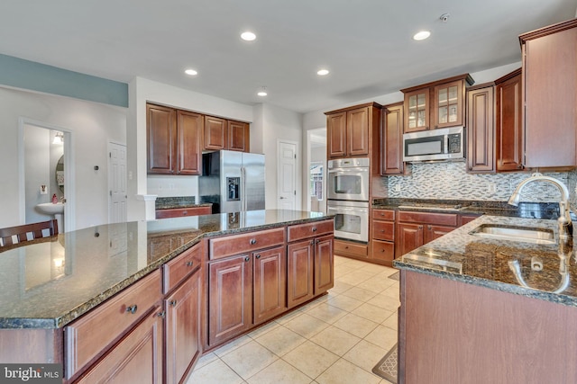 2708 Lake Forest Dr, Upper Marlboro, MD 20774 - kitchen featuring stainless steel appliances, a sink, tasteful backsplash, light tile patterned floors, and a center island