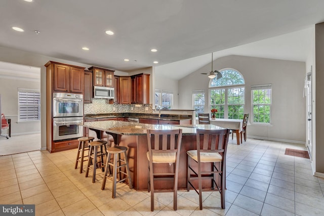 2708 Lake Forest Dr, Upper Marlboro, MD 20774 - kitchen with appliances with stainless steel finishes, light tile patterned flooring, lofted ceiling, a breakfast bar area, and a peninsula