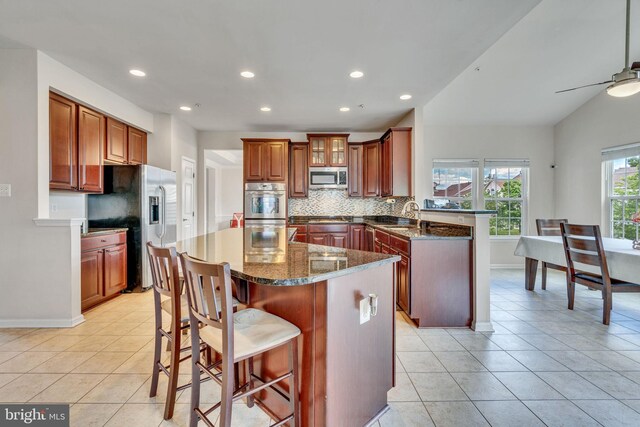 2708 Lake Forest Dr, Upper Marlboro, MD 20774 - kitchen with appliances with stainless steel finishes, a peninsula, tasteful backsplash, a kitchen island, and recessed lighting