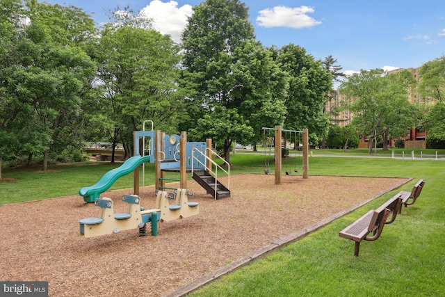 communal playground featuring a yard and view of scattered trees
