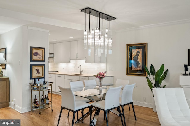 700 New Hampshire Ave NW Unit 507, Washington, DC 20037 - dining area with light wood-style floors, baseboards, and ornamental molding