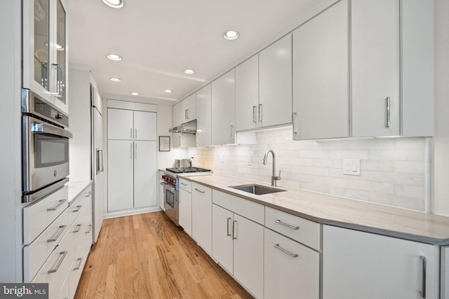700 New Hampshire Ave NW Unit 507, Washington, DC 20037 - kitchen with appliances with stainless steel finishes, a sink, light wood-style floors, white cabinetry, and recessed lighting