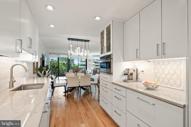 700 New Hampshire Ave NW Unit 507, Washington, DC 20037 - kitchen with a sink, stainless steel oven, white cabinetry, light stone counters, and recessed lighting