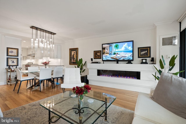700 New Hampshire Ave NW Unit 507, Washington, DC 20037 - living area featuring light wood-style flooring, crown molding, a glass covered fireplace, and a chandelier