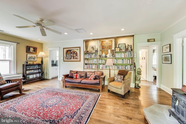 7017 Woodland Ave, Takoma Park, MD 20912 - living area with healthy amount of natural light, wood finished floors, a wood stove, recessed lighting, and ornamental molding
