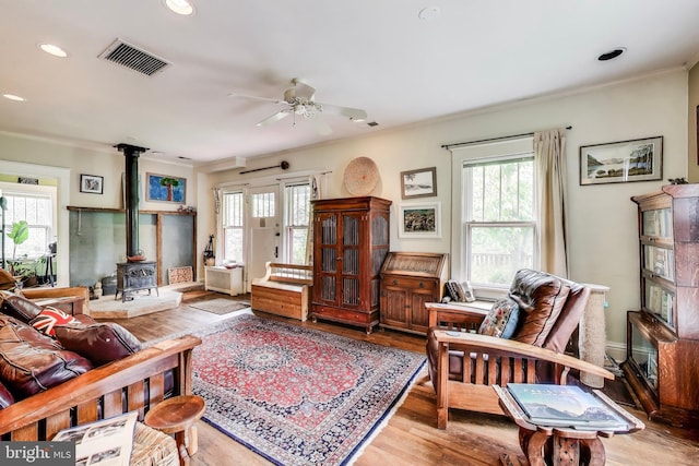 7017 Woodland Ave, Takoma Park, MD 20912 - living area featuring a wood stove, plenty of natural light, a ceiling fan, crown molding, and wood finished floors
