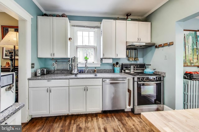 7017 Woodland Ave, Takoma Park, MD 20912 - kitchen with stainless steel appliances, radiator heating unit, under cabinet range hood, ornamental molding, and dark wood-style floors