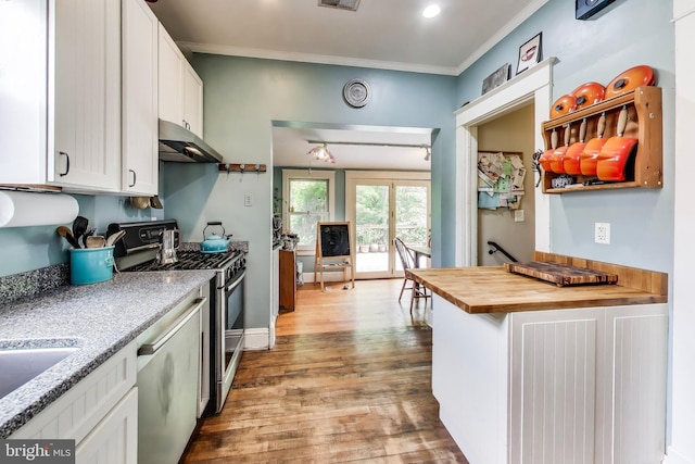 7017 Woodland Ave, Takoma Park, MD 20912 - kitchen featuring under cabinet range hood, appliances with stainless steel finishes, butcher block countertops, wood finished floors, and white cabinetry