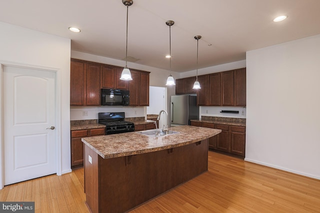 596 Claiborne Road, North East, MD 21901 - kitchen with black appliances, a sink, light wood-style floors, dark brown cabinets, and pendant lighting