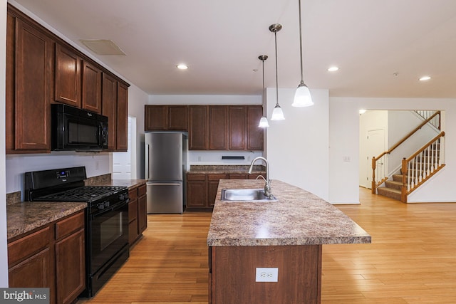 596 Claiborne Road, North East, MD 21901 - kitchen with black appliances, a sink, light wood finished floors, decorative light fixtures, and dark brown cabinets