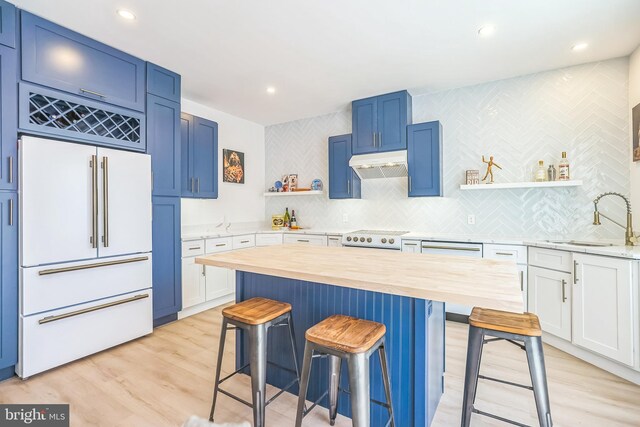 504 Richey Ave, Collingswood, NJ 08107 - kitchen with white built in refrigerator, butcher block countertops, under cabinet range hood, open shelves, and a kitchen breakfast bar