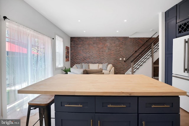 504 Richey Ave, Collingswood, NJ 08107 - kitchen with butcher block counters, white refrigerator, brick wall, a center island, and recessed lighting