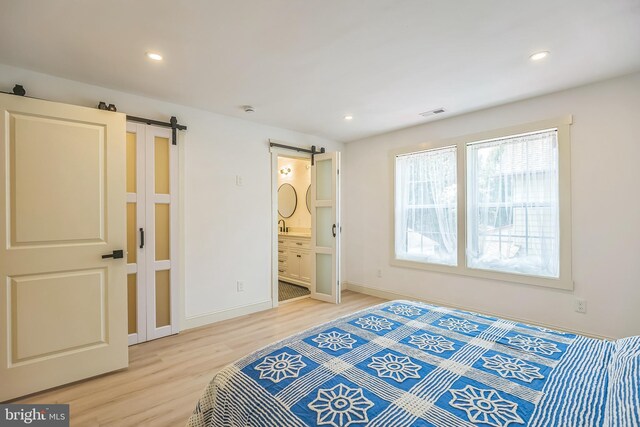 504 Richey Ave, Collingswood, NJ 08107 - bedroom with a barn door, light wood-type flooring, recessed lighting, and connected bathroom
