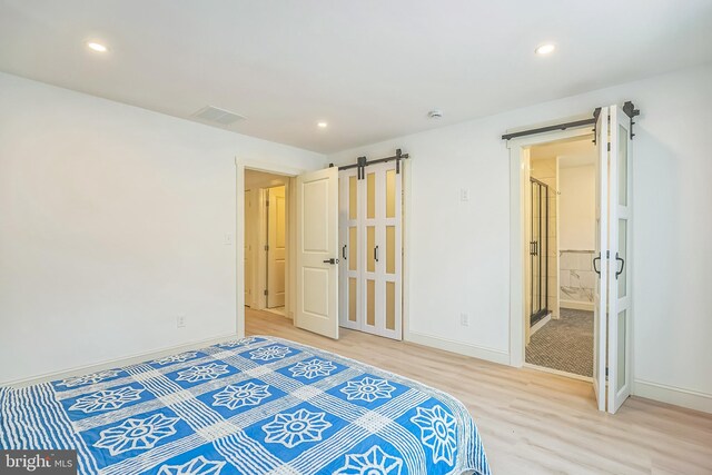 504 Richey Ave, Collingswood, NJ 08107 - bedroom with a barn door, light wood finished floors, recessed lighting, and connected bathroom