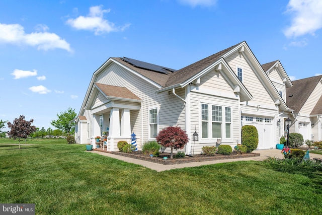 craftsman-style house featuring a garage, solar panels, a front lawn, and a shingled roof