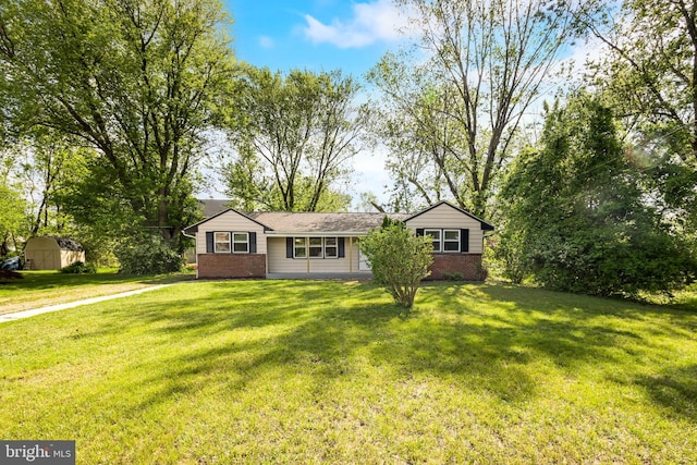 ranch-style house with brick siding, a front yard, a storage shed, and an outdoor structure