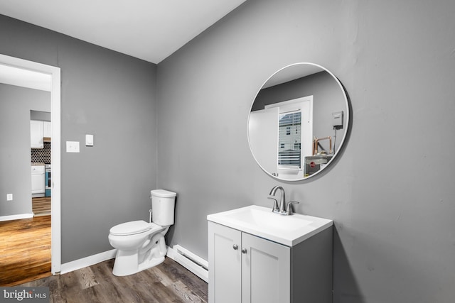 half bathroom with baseboard heating, wood finished floors, toilet, vanity, and tasteful backsplash