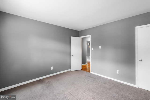 unfurnished bedroom featuring carpet floors and baseboards