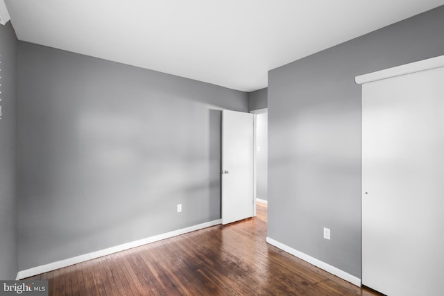 unfurnished bedroom with hardwood / wood-style floors and baseboards
