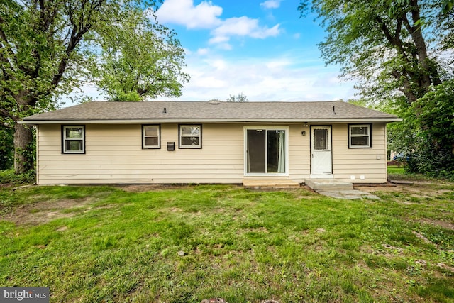 rear view of house featuring a lawn